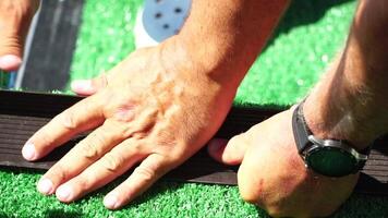 Man Cuting Artificial Grass carpet with knife. Artificial turf. Close up on hands. video