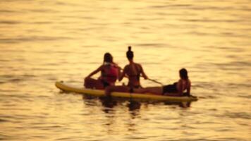 Defocused sea ocean beach of hotel or resort with Lounge bed on hot summer day. Abstract bokeh background of blurred resting and swimming people on beach at blue sea. Holiday, vacation and recreation. video