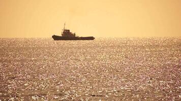 Tug boat in open calm sea, heading back to port at sunset, helps large container ships maneuver. Aerial view, maritime industry, oceanic transportation or business concepts. video