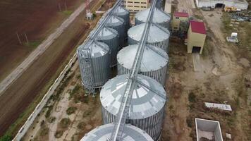 Grain elevator. Metal grain elevator in agricultural zone. Agriculture storage for harvest. Grain elevators on green nature background. Exterior of agricultural factory. Nobody. video