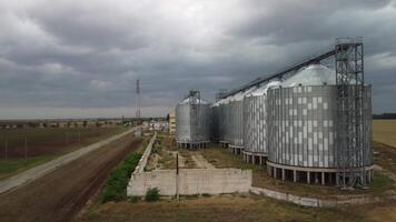 Grain elevator. Metal grain elevator in agricultural zone. Agriculture storage for harvest. Grain elevators on green nature background. Exterior of agricultural factory. Nobody. video