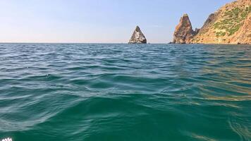 Sea water surface. Camera flies over the calm azure sea with volcanic rocky shores on background. Nobody. Holiday recreation concept. Abstract nautical summer ocean nature. Slow motion. Close up video