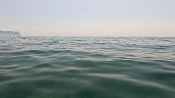 Sea water surface background. Low angle view from kayak, camera flies over the clear green sea water. Nobody. Holiday recreation concept. Abstract nautical summer ocean nature. Slow motion. video