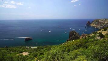 Aerial panoramic view of seascape with crystal clear azure sea and rocky shores. Yachts in a beautiful lagoon on backdrop of rocks. The concept of an ideal destination for summer travel and vacation. video