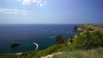 Aerial panoramic view of seascape with crystal clear azure sea and rocky shores. Yachts in a beautiful lagoon on backdrop of rocks. The concept of an ideal destination for summer travel and vacation. video