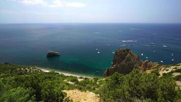 Antenne Panorama- Aussicht von Seelandschaft mit Kristall klar azurblau Meer und felsig Ufer. Yachten im ein schön Lagune auf Hintergrund von Felsen. das Konzept von ein Ideal Ziel zum Sommer- Reise und Urlaub. video