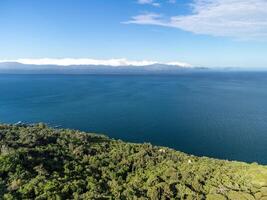 Aerial sea clouds. Panoramic view of seascape with crystal clear azure sea. Yachts in a beautiful lagoon on backdrop of rocks. The concept of an ideal destination for summer travel and vacation. photo