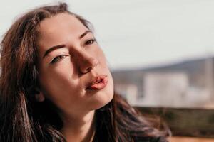 contento joven sonriente mujer con pecas al aire libre retrato. suave soleado colores. al aire libre de cerca retrato de un joven morena mujer y mirando a el cámara, posando en contra otoño naturaleza antecedentes foto