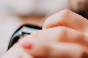 Woman hand using smart watches mobile app with touch screen. New gadget to stay connected to internet. Stylish touchscreen wrist watches with navigation mobile application. Close up. Selective focus photo