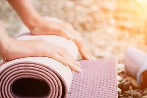 Pilates magic ring and rubber band on yoga mat near sea. Female fitness yoga concept. Healthy lifestyle harmony and meditation. photo