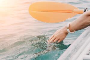 Woman in kayak back view. Happy young woman with long hair floating in transparent kayak on the crystal clear sea. Summer holiday vacation and cheerful female people relaxing having fun on the boat photo