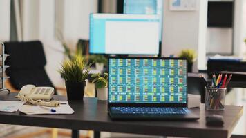 Desk in empty office with laptop showing stock exchange data collected to develop trading strategies. Forex analytics on notebook screen in company workplace showing trading platform video