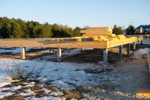 The foundation of a wooden frame house on stilts is a construction site, the process of building a frame photo