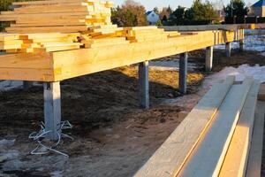 The foundation of a wooden frame house on stilts is a construction site, the process of building a frame photo