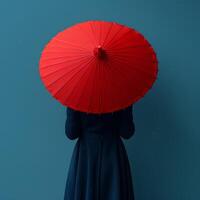 AI generated Girl with red umbrella on blue background with her back turned to the camera. Girl holding umbrella in front of a background. Person under umbrella photo