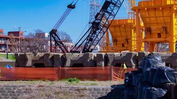 A timelapse of moving cranes at the under construction telephoto shot panning video