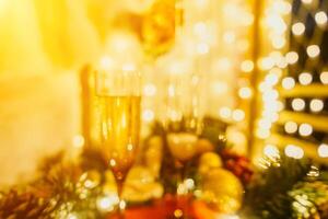 Two champagne glasses filled with champagne are placed on a table with a fruit arrangement. The glasses are surrounded by lights, creating a festive atmosphere. photo