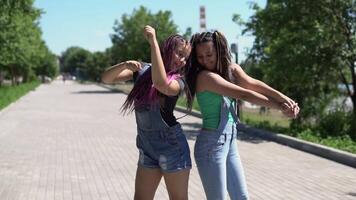 Two beautiful girlfriends are happy and fooled in the park in sunny weather. slow motion video