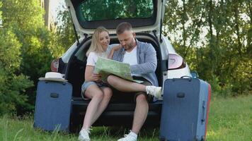content couple en voyageant par auto. homme et femme à la recherche à une route carte. actif loisir pour le famille video