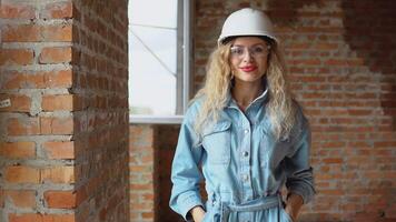 le processus de bâtiment une rêver maison. logement pour Jeune des familles. une Jeune femme dans une travail casque et denim vêtements et des lunettes de protection des stands à le construction placer. video