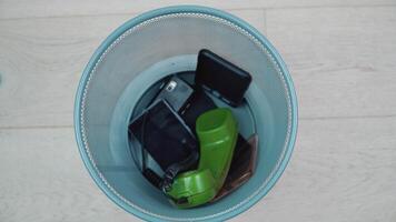 Trash can with mobile phones of different eras revolves around its axis video