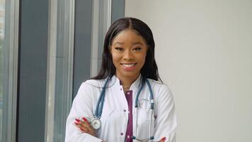 A young African American female graduate in a white medical gown smiles and poses for the camera. An important event. Young specialist video