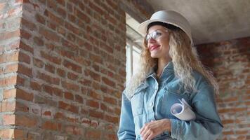 Female architect holding an architectural construction plan while on the construction site. video