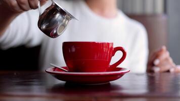 vicino su donna con tazza di caffè, godendo caldo bevanda nel il mattina mentre sedersi nel moderno vivente camera prima inizio opera. rompere, pausa, sognare ad occhi aperti concetto video