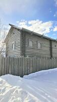 Wooden boards, fence, wooden house, natural materials, logs, beams, gates, winter in the village photo