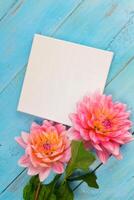 summer background. dahlias and a canvas on a blue wooden background. art. space for a text photo