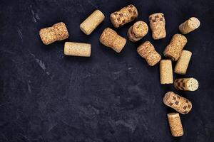 wine corks on a black textured surface. top view. place for text photo