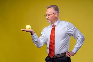 Portrait of attractive man posing on camera. Holding yellow apple in hand. Isolated over white background. photo