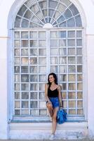 Young girl standing near vintage arque wooden window. Urban style girl. White background. Fashion portrait. photo