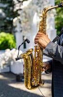 manos de hombre jugando saxofón. cerca arriba ver de el manos de un masculino saxofonista jugando un tenor saxofón. jazz, clásico y blues música a boda. foto