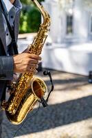 joven hombre jugando el saxofón a el boda. borroso antecedentes. selectivo enfocar. foto