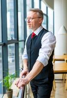 Man standing near window in modern room with high panoramic windows. photo