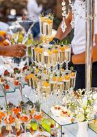 Pyramid of glasses of champagne. Wedding table decoration. Celebration and party. Catering concept. photo