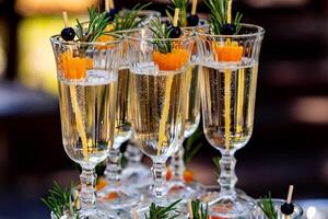 Holiday setting of wedding table. Glasses of champagne in lines. Selective focus, front view. Close up. photo