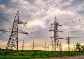 High voltage post. High voltage pylons against sunset background. Energy and industrialisation concept. Selective focus photo