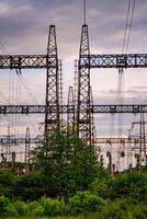 Energy distribution network. Electricity pylons against orange and yellow sunset. Selective focus. photo