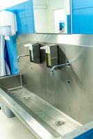 Sterile steel washbasin in modern surgery room. photo