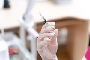 Syringe with medicine in hand for injection. Prevention and health care concept. Close-up photo