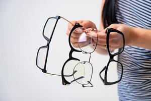 Eyeglasses closeup. Spectacles in woman's hands. Many glasses. Front view. Zoom in. photo