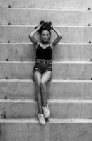 Fashion and style. Beautiful brunette lying on the steps. View from above. Black and white portrait. Vertical photo. photo