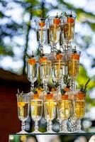 A row of champagne glasses. Vertical stand with three levels of glasses. Blurred background. Close up. photo