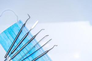 Denture and dental instruments. Medical mask. Individual dental treatment. Metal stomatology instruments. photo