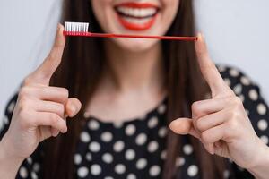 Portrait of beautiful young woman with toothbrush in hands. Healthy white teeth. Dental concept. photo