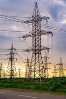 High voltage electric tower. Silhouette on sunset time. Power pylons on sunset time background. Selective focus photo