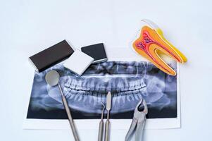 Dental instruments and jaw x-ray on white background. Panoramic jaw x-ray on white background. photo