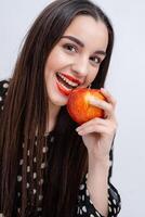 Beautiful young pretty woman, model, girl with red lips. Girl eating an apple, smiling. Closeup photo